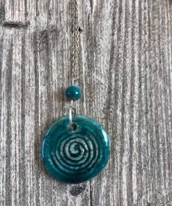 foto di una collana con ciondolo in ceramica raku color verde turchese con una spirale incisa e una pallina in ceramica raku